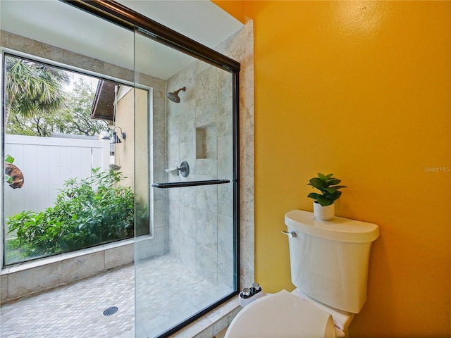 bathroom featuring toilet and a stall shower