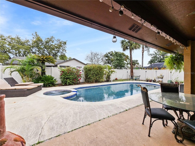 view of pool with a fenced backyard, a pool with connected hot tub, outdoor dining area, and a patio