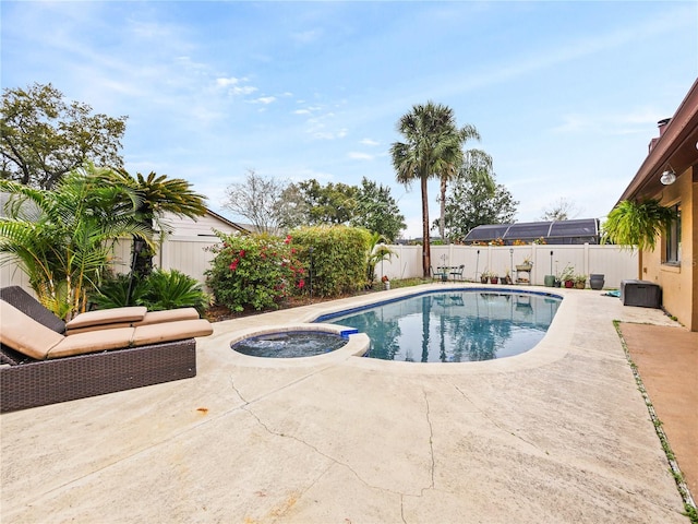 view of swimming pool with a fenced backyard, a pool with connected hot tub, and a patio