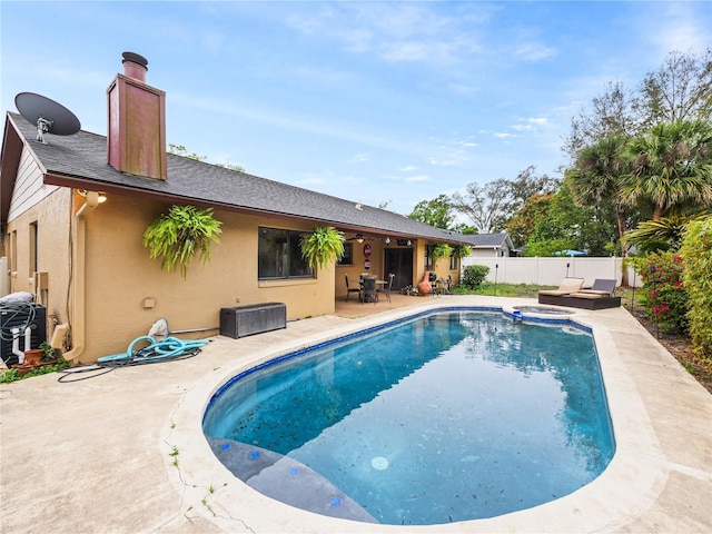 view of pool with a patio, a fenced backyard, and a pool with connected hot tub