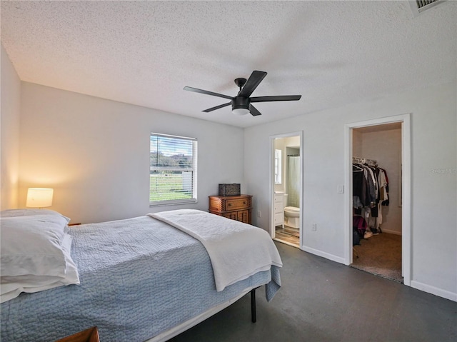 bedroom featuring a walk in closet, a closet, visible vents, and a textured ceiling