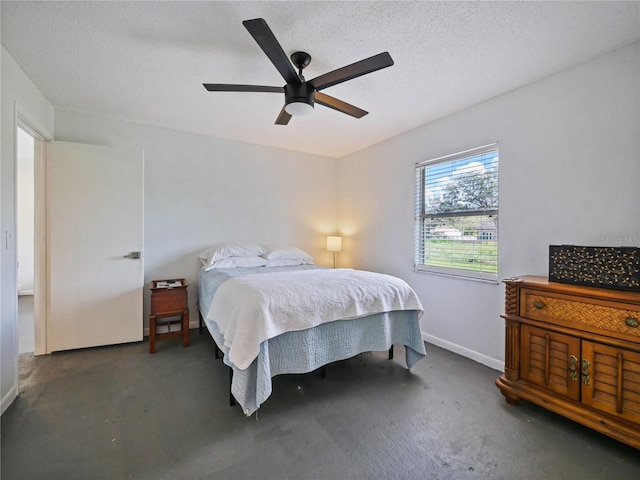 bedroom featuring a textured ceiling, ceiling fan, concrete floors, and baseboards