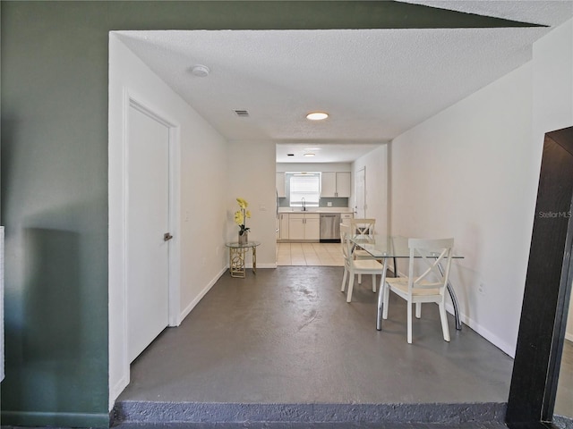 dining area featuring finished concrete floors, a textured ceiling, and baseboards