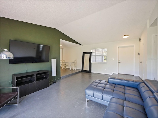 living area with concrete flooring, vaulted ceiling, and baseboards