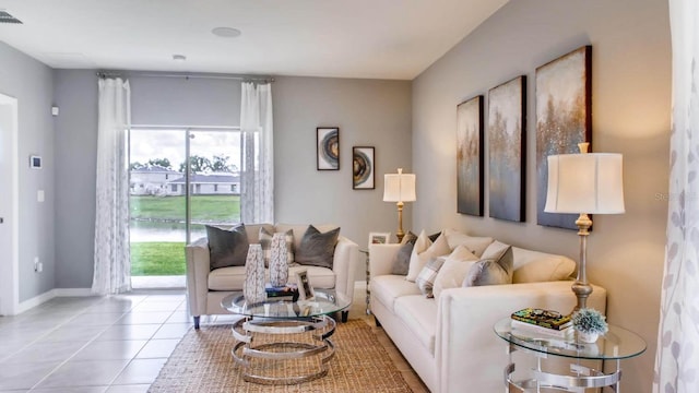 living area featuring light tile patterned flooring, visible vents, and baseboards