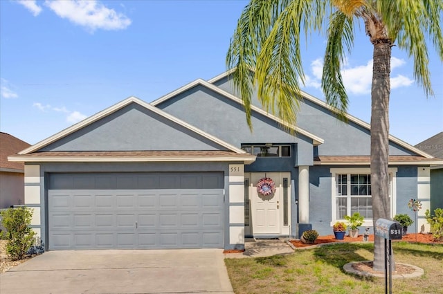 ranch-style house with a garage, driveway, and stucco siding