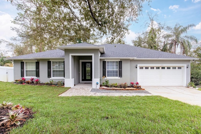 view of front of property with stucco siding, a front yard, fence, a garage, and driveway