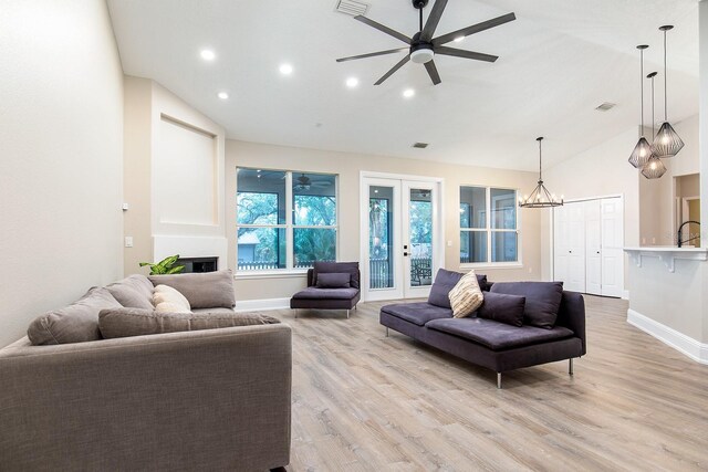 living area featuring baseboards, visible vents, a ceiling fan, french doors, and light wood-style floors