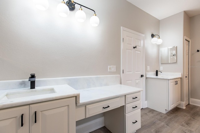 bathroom featuring wood finished floors, vanity, and baseboards