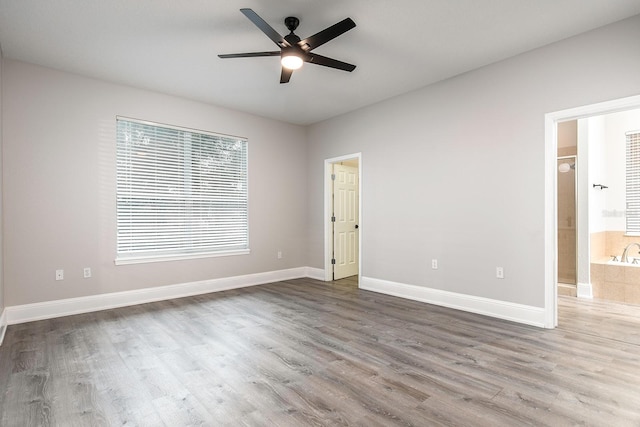 unfurnished room featuring a ceiling fan, baseboards, and wood finished floors