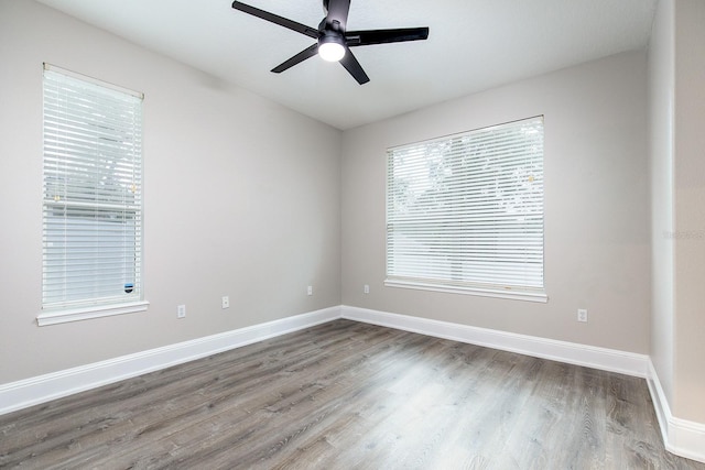 unfurnished room featuring wood finished floors, a ceiling fan, and baseboards