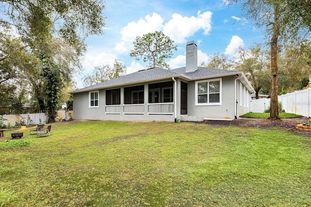 back of property featuring a fenced backyard, a lawn, a chimney, and stucco siding