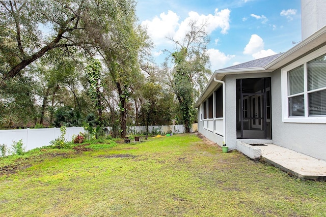 view of yard featuring a sunroom and a fenced backyard