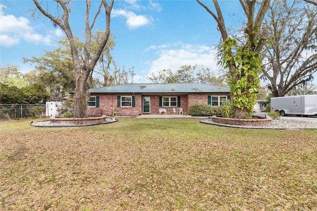 view of front of house featuring brick siding, fence, and a front lawn