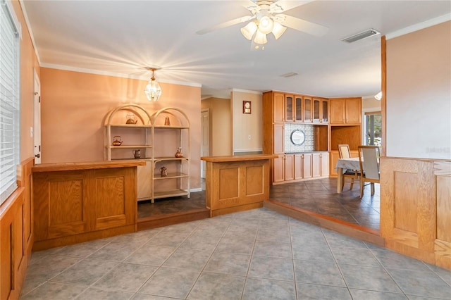 kitchen with ornamental molding, tile patterned flooring, and visible vents