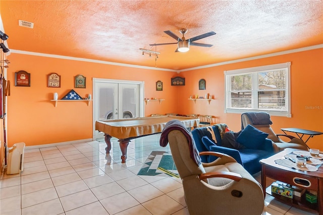 game room featuring light tile patterned floors, ceiling fan, ornamental molding, and visible vents