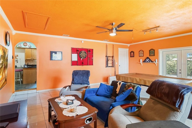 living area with french doors, light tile patterned floors, ornamental molding, a ceiling fan, and a textured ceiling