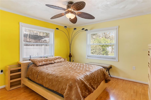 bedroom featuring ornamental molding, multiple windows, wood finished floors, and baseboards