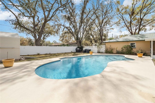 view of swimming pool with a fenced in pool, an outbuilding, a patio area, and a fenced backyard