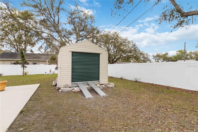 exterior space with a storage shed, an outdoor structure, a fenced backyard, and a detached garage