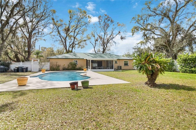 view of pool with a fenced in pool, a sunroom, fence, a yard, and a patio area