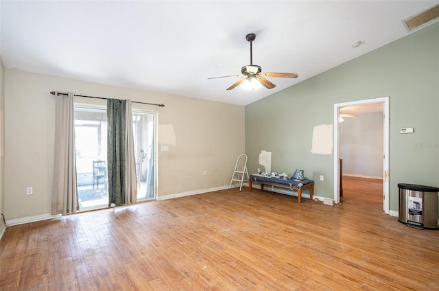 empty room with light wood-type flooring, lofted ceiling, visible vents, and baseboards