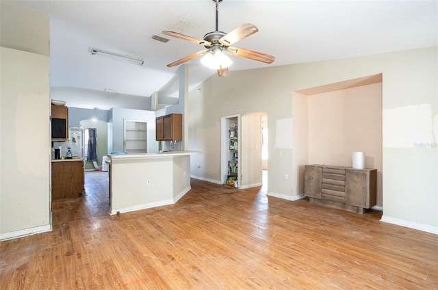 kitchen with lofted ceiling, light wood-style floors, open floor plan, ceiling fan, and a peninsula