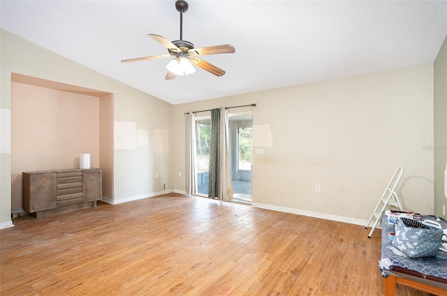 spare room with light wood-type flooring, vaulted ceiling, baseboards, and ceiling fan