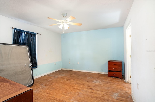 bedroom featuring ceiling fan, baseboards, and wood finished floors