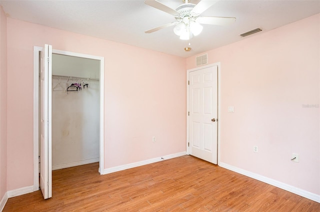 unfurnished bedroom featuring a closet, visible vents, light wood-style flooring, and baseboards