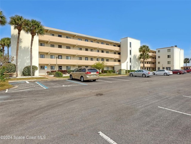 view of building exterior with uncovered parking