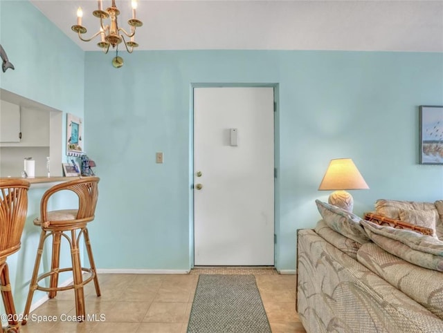 foyer entrance featuring baseboards, a chandelier, and light tile patterned flooring