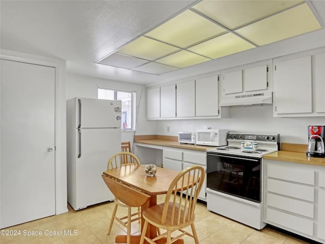 kitchen featuring white appliances, light tile patterned floors, white cabinets, light countertops, and under cabinet range hood