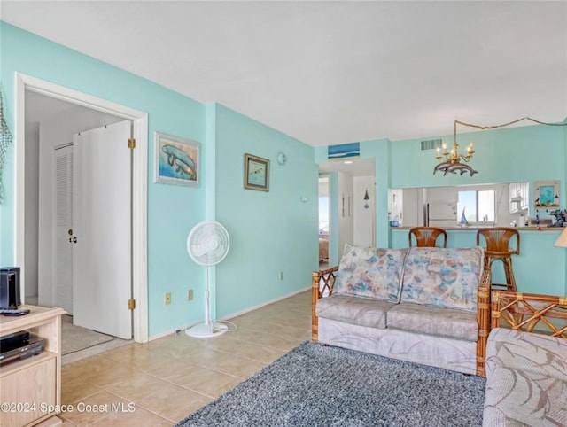 living room with visible vents, a notable chandelier, baseboards, and light tile patterned floors