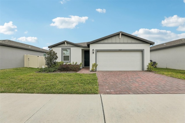 ranch-style house with decorative driveway, an attached garage, board and batten siding, and a front yard