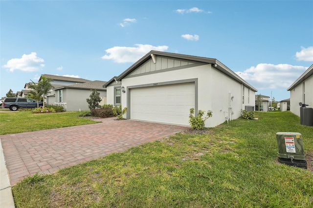 view of front of home with a front lawn, decorative driveway, an attached garage, and board and batten siding