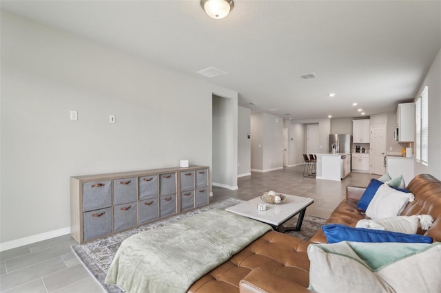 living room with recessed lighting, light tile patterned flooring, visible vents, and baseboards