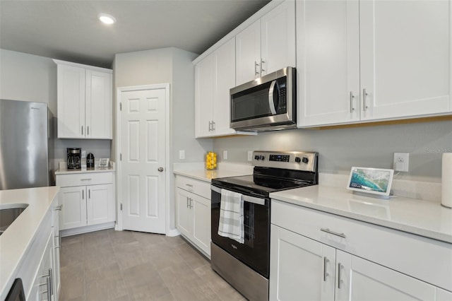 kitchen with light countertops, appliances with stainless steel finishes, white cabinetry, and recessed lighting