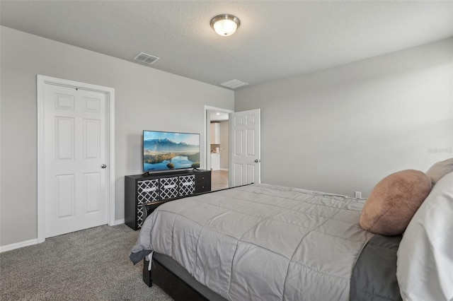 bedroom with a textured ceiling, carpet, visible vents, and baseboards