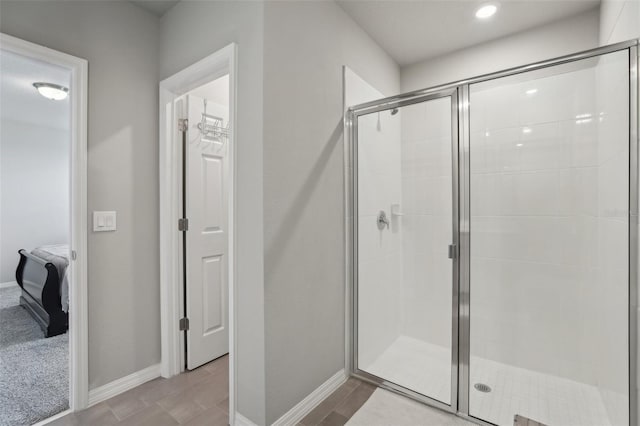 ensuite bathroom featuring a shower stall, baseboards, and ensuite bathroom