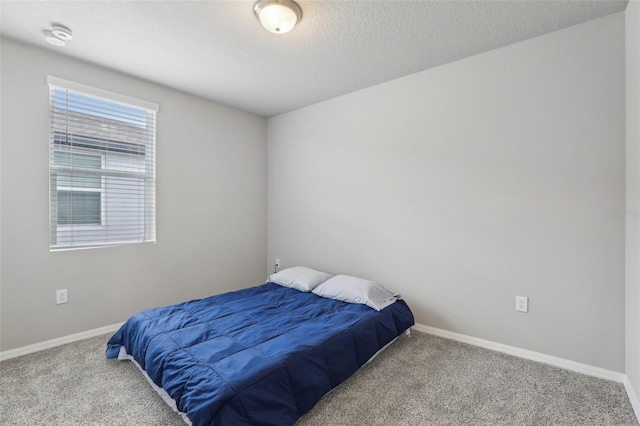 carpeted bedroom with a textured ceiling and baseboards