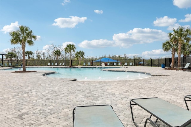 community pool with fence and a patio