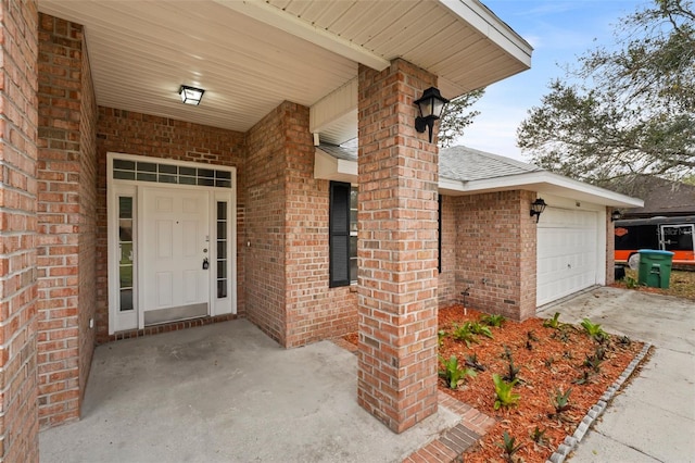 doorway to property with driveway, brick siding, an attached garage, and a shingled roof