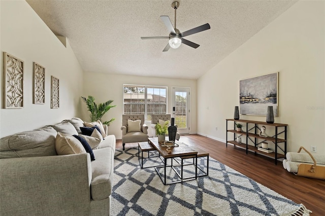 living room featuring lofted ceiling, ceiling fan, a textured ceiling, and dark wood finished floors