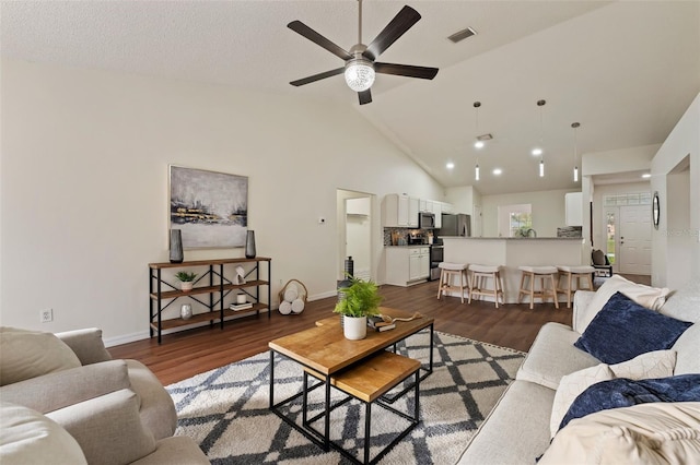 living room with dark wood-style floors, baseboards, visible vents, and high vaulted ceiling