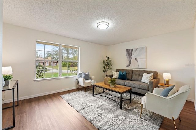 living room with dark wood-style floors, baseboards, and a textured ceiling