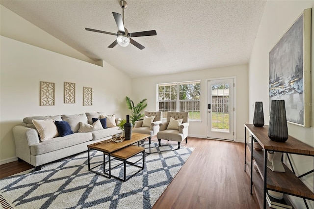 living room featuring lofted ceiling, a textured ceiling, and wood finished floors