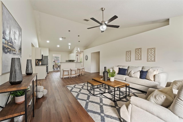 living area with high vaulted ceiling, dark wood-style floors, visible vents, and a ceiling fan