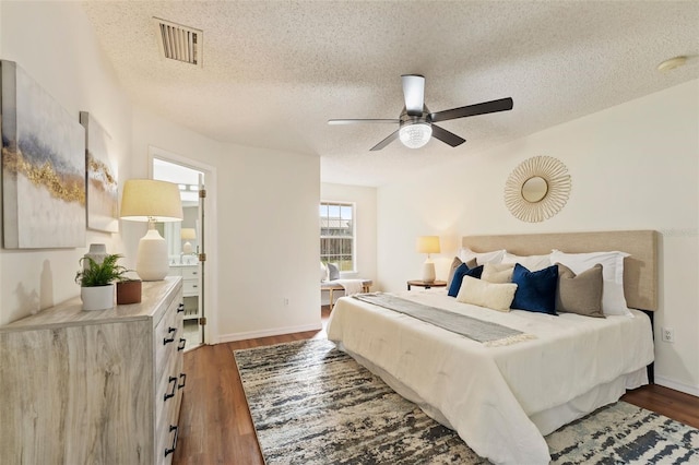 bedroom featuring a textured ceiling, dark wood finished floors, and visible vents