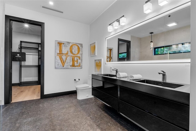 bathroom with baseboards, visible vents, a sink, and toilet